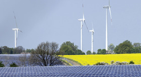 Wind turbines and solar panels in a field