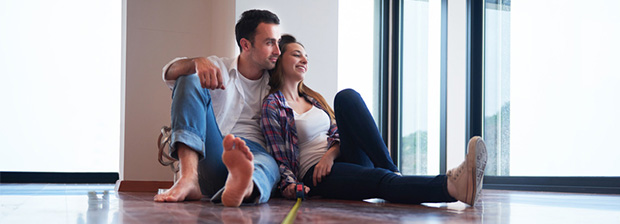 Couple sitting on the floor of their new house.