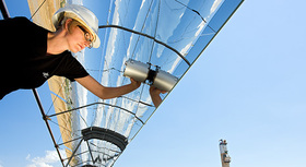 Female engineer inspecting solar panel.