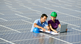 Male and female engineer inspecting PV modules.