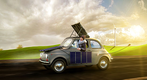 woman in a small car with solar panels on roof