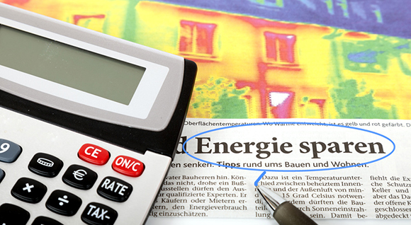Taschenrechner und Zeitungsartikel zu Energiesparen