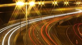 Autobahn bei Nacht mit leuchtenden Straßenlaternen