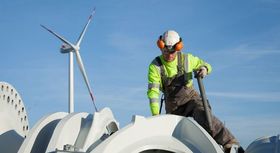 Bild zeigt einen Mann bei der Arbeit auf einer Windkraftanlage