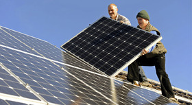Dachdecker installieren Solarpaneele auf einem Haus.