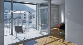 Innenaufnahme eines Smart Home (Blick aud dem Wohnzimmer auf eine sonnige Terrasse)