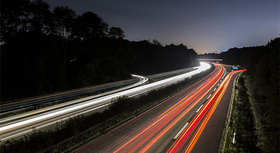 Langzeitaufnahme einer Autobahn bei Nacht.