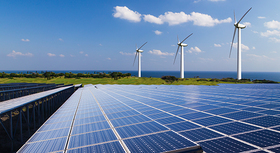 Solarfarm mit drei Windrädern im Hintergrund