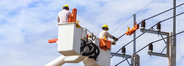 Zwei Arbeiter führen Reparaturarbeiten an einer Stromleitung durch.