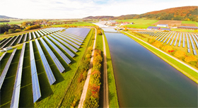Solarpanele zu beiden Seiten eines Kanals im Grünen